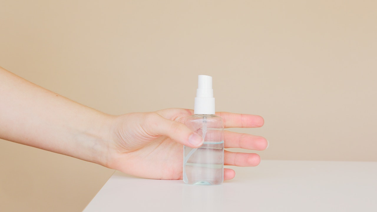Spray bottle on the table hold in the hand