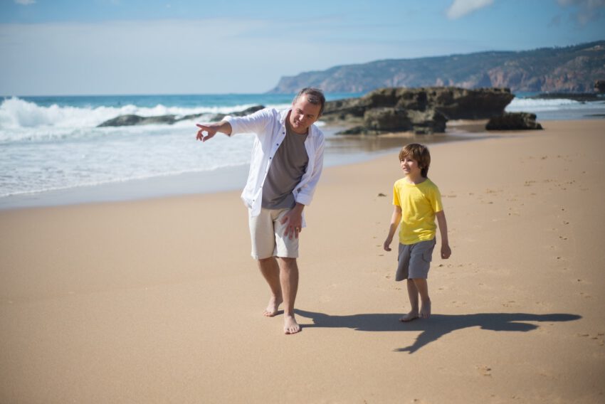 Man and his son are on the beach wearing beach pants